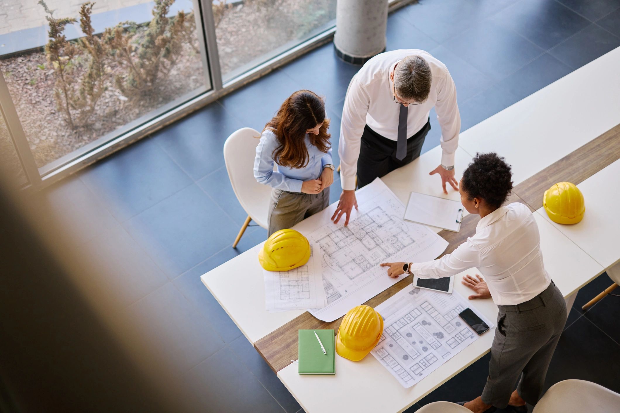 Engineering team collaborating over project plans in a modern office
